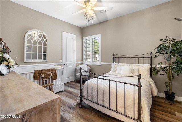 bedroom featuring a ceiling fan, baseboards, visible vents, and wood finished floors