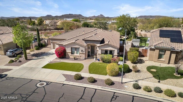 mediterranean / spanish house with a mountain view, a tile roof, fence, concrete driveway, and stucco siding