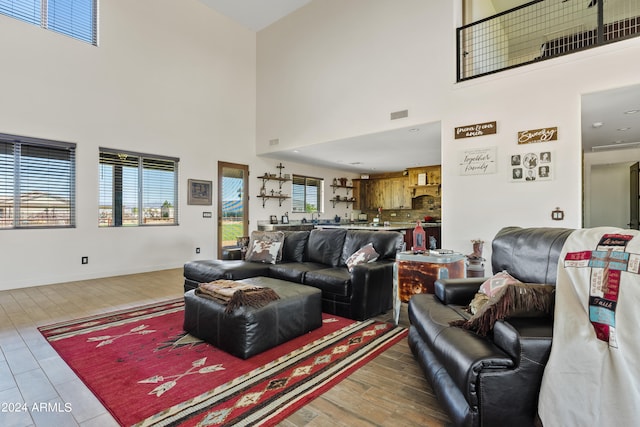 living room featuring wood-type flooring and a high ceiling