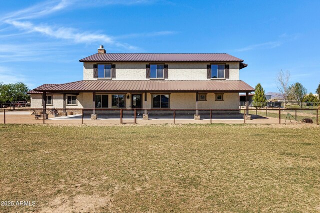 rear view of house featuring covered porch, a yard, and a garage