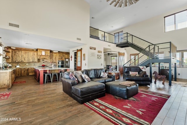 living room with dark hardwood / wood-style flooring, sink, and a high ceiling