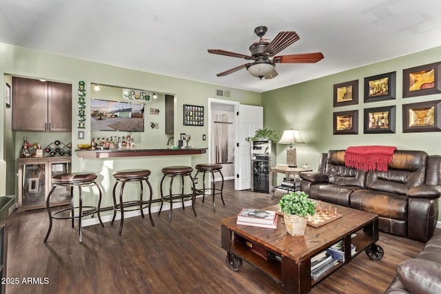 living room featuring ceiling fan and dark hardwood / wood-style floors