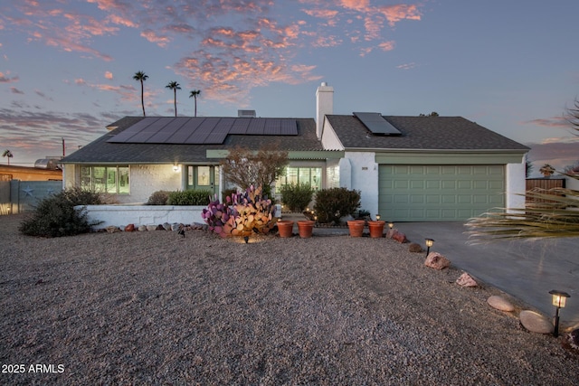 view of front of house with solar panels and a garage