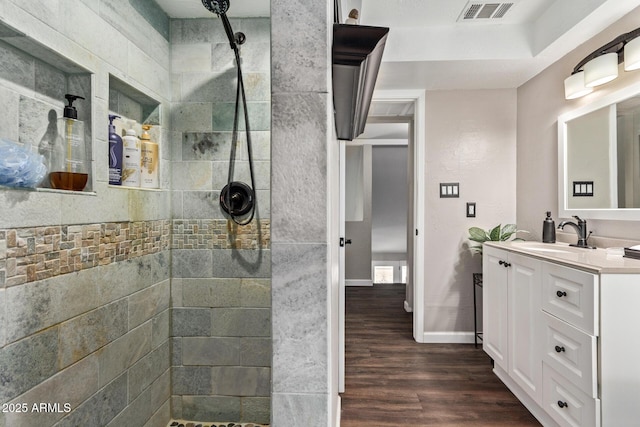 bathroom featuring tiled shower, vanity, and hardwood / wood-style flooring