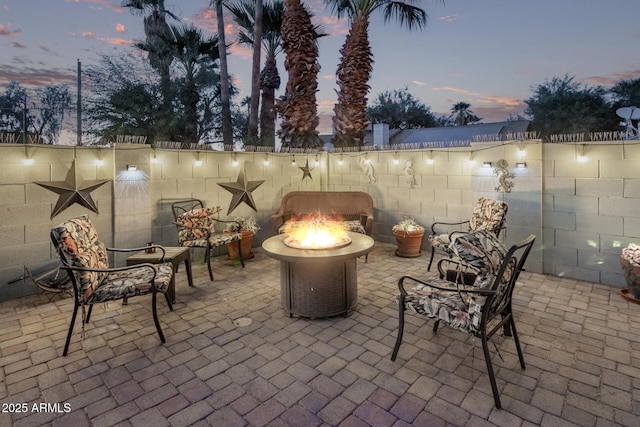 patio terrace at dusk featuring an outdoor fire pit