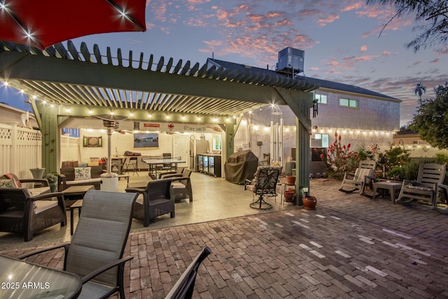 patio terrace at dusk featuring area for grilling and a pergola