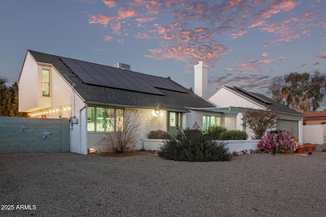 view of front of home with a garage and solar panels