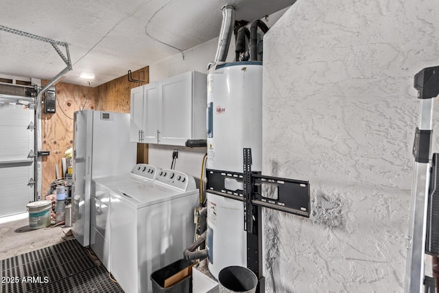 clothes washing area with cabinets, electric water heater, and washing machine and dryer