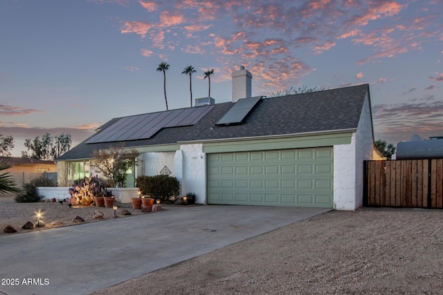 view of front facade featuring a garage and solar panels