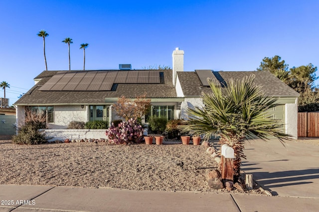 single story home with solar panels and a garage