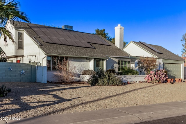 view of front of home featuring solar panels and a garage