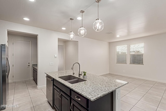 kitchen with a center island with sink, sink, hanging light fixtures, stainless steel appliances, and light tile patterned floors