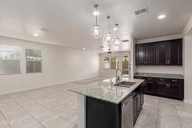 kitchen featuring ceiling fan, decorative light fixtures, dishwasher, sink, and a kitchen island with sink