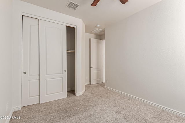 unfurnished bedroom with ceiling fan, a closet, and light carpet