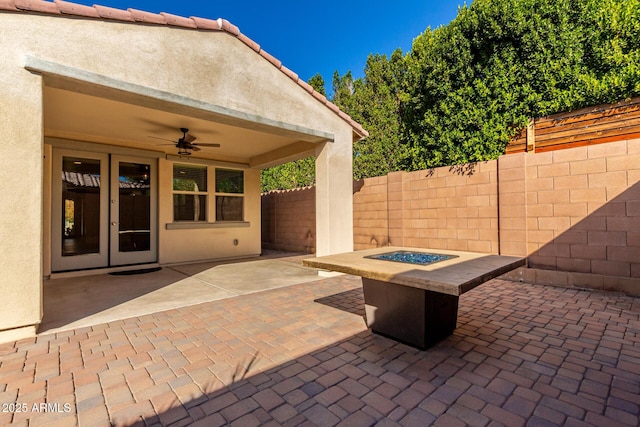 view of patio featuring ceiling fan and a fire pit