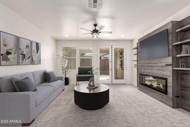 carpeted living room with ceiling fan and french doors