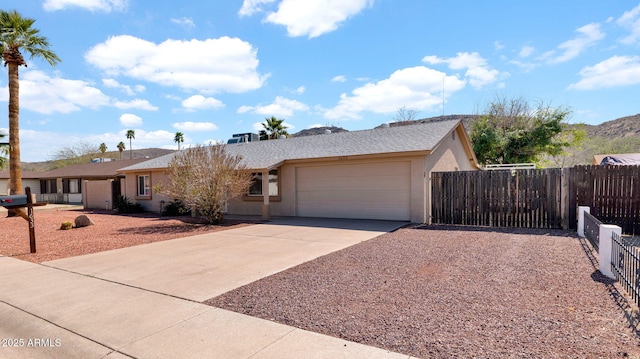 ranch-style home with concrete driveway, an attached garage, fence, and stucco siding