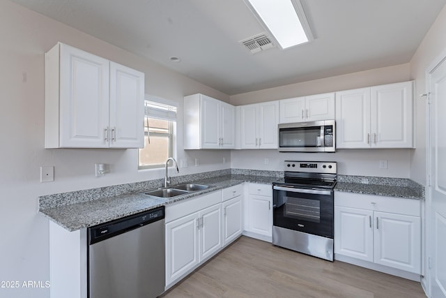 359 E Watson Pl, Casa Grande, AZ 85122 - kitchen featuring stainless steel appliances, a sink, white cabinetry, light wood-style floors, and stone countertops