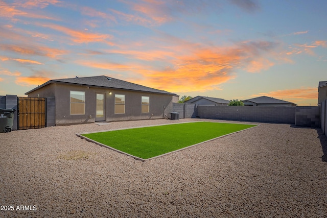 359 E Watson Pl, Casa Grande, AZ 85122 - back of house at dusk featuring central air condition unit, stucco siding, and a patio