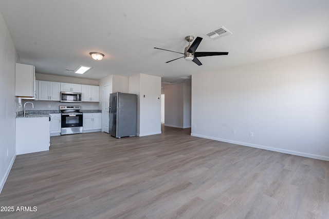 359 E Watson Pl, Casa Grande, AZ 85122 - unfurnished living room featuring baseboards, light wood-type flooring, ceiling fan, and a sink