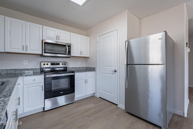 359 E Watson Pl, Casa Grande, AZ 85122 - kitchen with appliances with stainless steel finishes, light wood-style floors, white cabinetry, and stone countertops