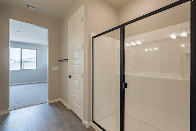 bathroom with visible vents, baseboards, a stall shower, and wood finished floors