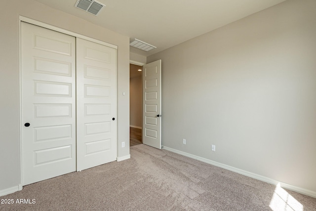 unfurnished bedroom with a closet, carpet flooring, baseboards, and visible vents