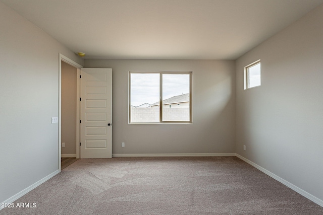 empty room featuring carpet floors and baseboards