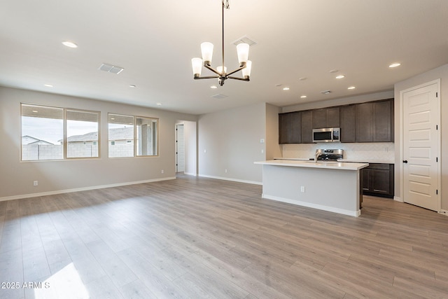 kitchen featuring visible vents, open floor plan, appliances with stainless steel finishes, and a notable chandelier