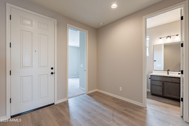 entrance foyer with recessed lighting, light wood-style flooring, and baseboards
