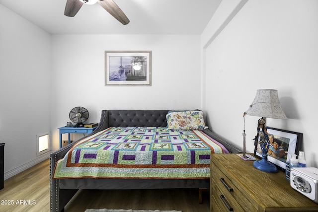 bedroom featuring a ceiling fan, baseboards, and wood finished floors