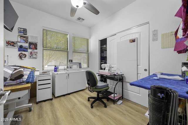 office area with washing machine and clothes dryer, a ceiling fan, light wood-style flooring, and visible vents