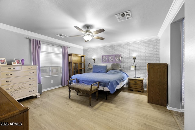 bedroom featuring crown molding, light wood-style flooring, and visible vents