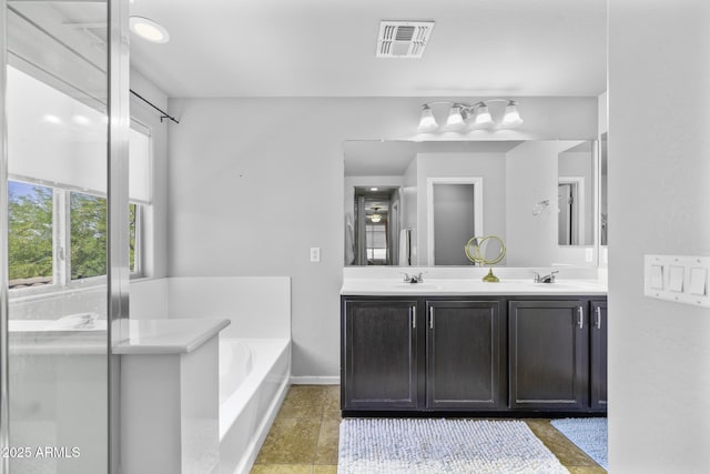 full bath with double vanity, visible vents, a sink, and a bath