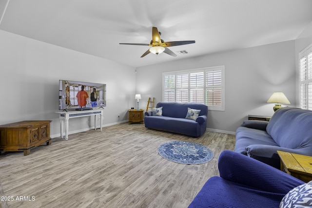living room with baseboards, a ceiling fan, wood finished floors, and visible vents