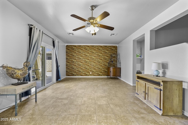unfurnished living room featuring baseboards, ceiling fan, brick wall, and visible vents