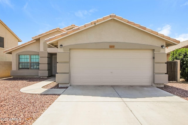 6875 W Townley Ave, Peoria, AZ 85345 - view of front of house featuring driveway, stucco siding, an attached garage, and a tiled roof