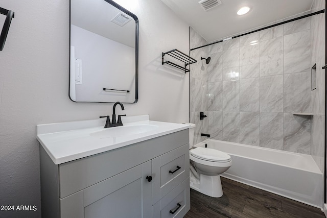 full bath featuring visible vents, toilet, shower / bathtub combination, wood finished floors, and vanity