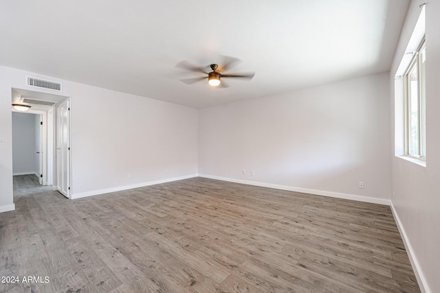 unfurnished room with visible vents, ceiling fan, light wood-style flooring, and baseboards