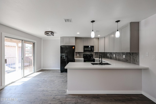 kitchen with light countertops, visible vents, black appliances, and a peninsula