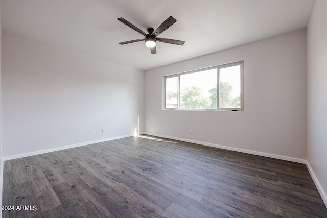 unfurnished room with dark wood-style flooring, ceiling fan, and baseboards