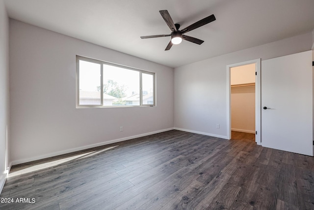 spare room featuring dark wood-type flooring, ceiling fan, and baseboards