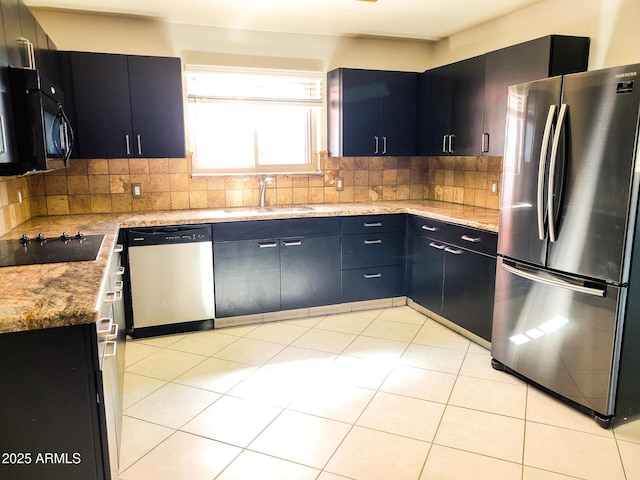 kitchen featuring light stone countertops, black appliances, and tasteful backsplash