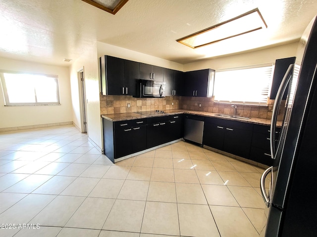 kitchen with light tile patterned flooring, black appliances, tasteful backsplash, and a healthy amount of sunlight