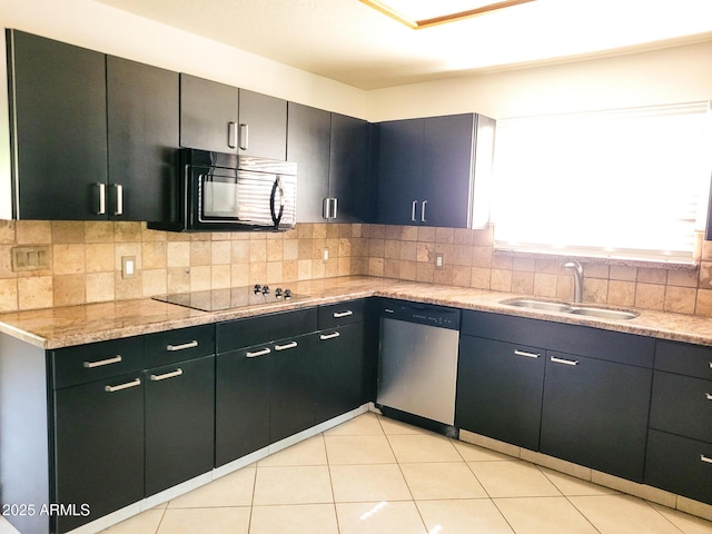 kitchen featuring sink, light stone countertops, light tile patterned flooring, black appliances, and decorative backsplash