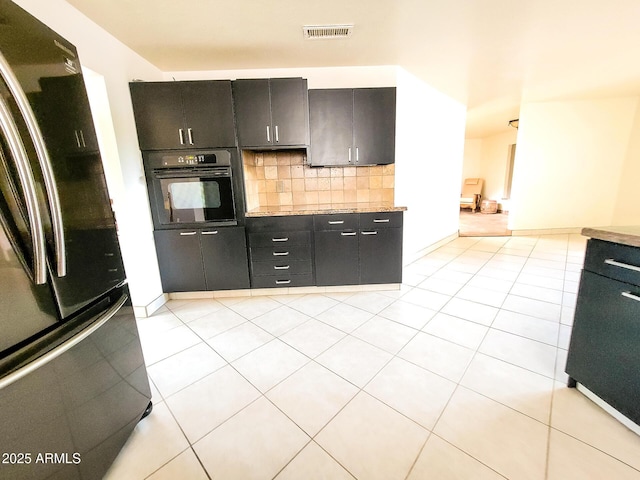 kitchen featuring backsplash, black appliances, and light tile patterned flooring