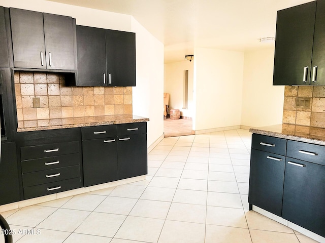 kitchen featuring light stone counters, tasteful backsplash, and light tile patterned flooring