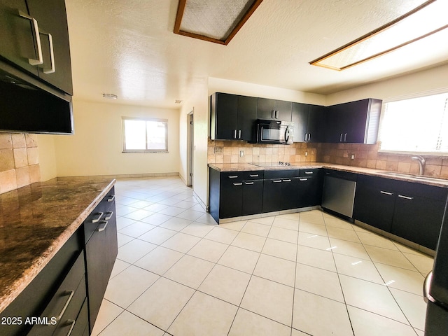 kitchen featuring black appliances, light tile patterned flooring, decorative backsplash, and sink