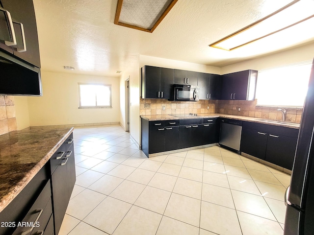 kitchen with black appliances, a wealth of natural light, light tile patterned floors, and sink