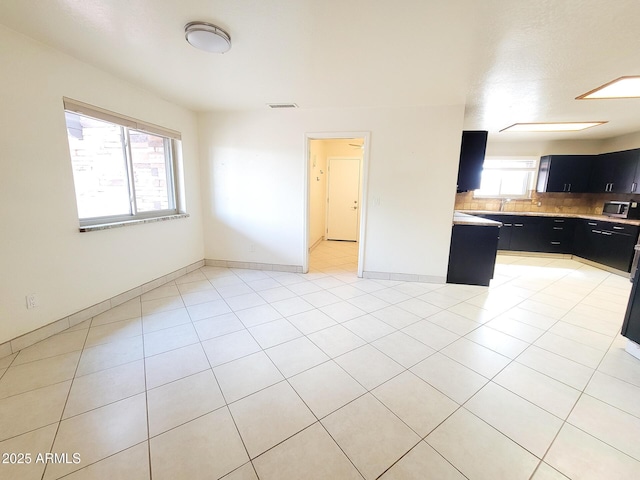 kitchen featuring light tile patterned flooring and backsplash